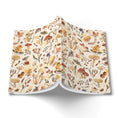 Load image into Gallery viewer, A folded fabric item, likely a blanket or throw, featuring an all-over autumn woodland pattern of mushrooms, acorns, leaves, and wildflowers on a cream background. The item is displayed on a clean white background with a soft drop shadow.