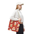 Load image into Gallery viewer, Person holding a red tote bag with cat pattern on a white background
