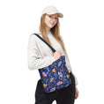 Load image into Gallery viewer, Person holding a colorful bag with butterfly design on a white background