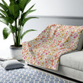 Load image into Gallery viewer, Floral-patterned blanket draped over a sofa in a living room with a plant and rug.