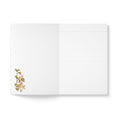 Load image into Gallery viewer, An open lined notebook with a white cover and a delicate botanical illustration in the lower left corner, set against a clean white background.