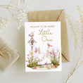 Load image into Gallery viewer, Greeting card with baby lamb illustration and 'Welcome to the World Little One' text, surrounded by decorative elements on a light background.