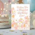 Load image into Gallery viewer, Birthday card with floral design and cake in the background