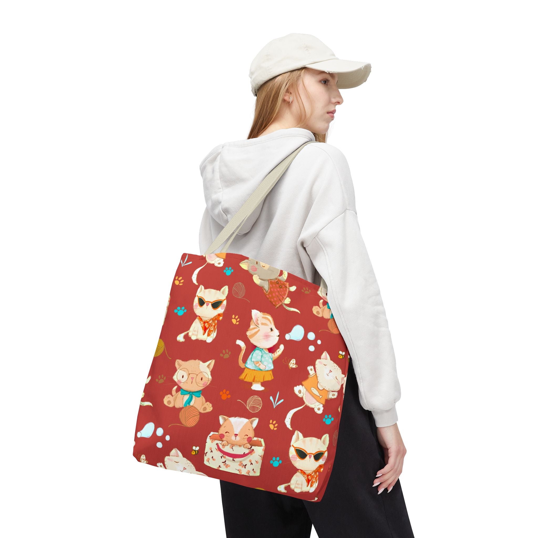 Person holding a tote bag with cat pattern on a white background