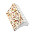 Load image into Gallery viewer, A stack of notebooks with a cream-colored cover decorated with a detailed botanical and mycological illustration pattern of mushrooms, flowers, and leaves. The notebooks are shown fanned out against a solid white background.
