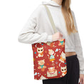 Load image into Gallery viewer, Person holding a tote bag with cartoon cat design on a red background
