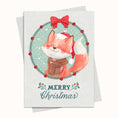 Load image into Gallery viewer, A Christmas greeting card featuring a watercolor illustration of a fox in a Santa hat and plaid sweater, framed by a holly wreath with a red bow, with 'MERRY Christmas' written below. The card is shown with a matching envelope on a light cream background.
