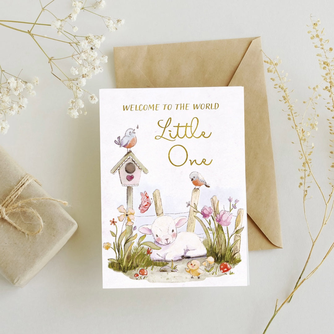 Greeting card with baby lamb illustration and 'Welcome to the World Little One' text, surrounded by decorative elements on a light background.